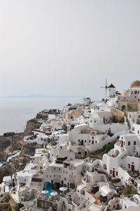 High angle view of townscape by sea against clear sky