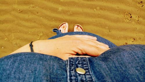 Low section of woman standing at beach