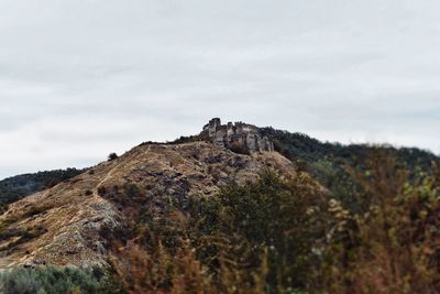 Low angle view of rocks on mountain against sky