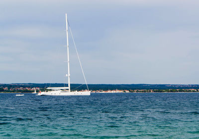 Sailboat sailing on sea against sky