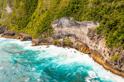 Clean calm blue sea, white foam near shore. drone view high cliff. bali, klungkung, indonesia