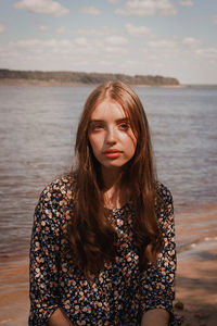 Portrait of young woman against lake