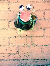 Close-up of smiley face on brick wall