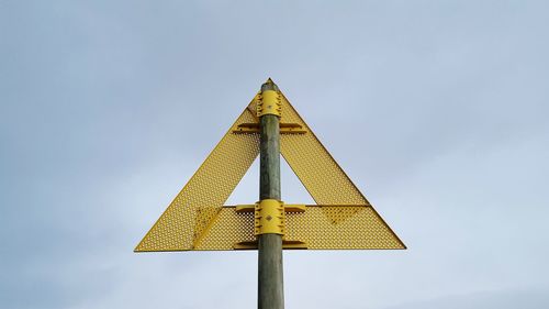 Low angle view of road sign against sky