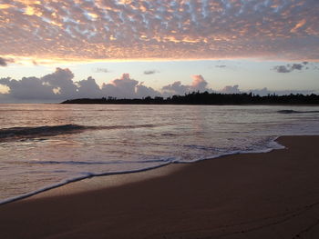 Scenic view of beach against cloudy sky