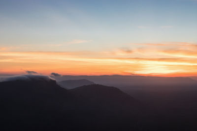 Scenic view of silhouette mountains against sky at sunset