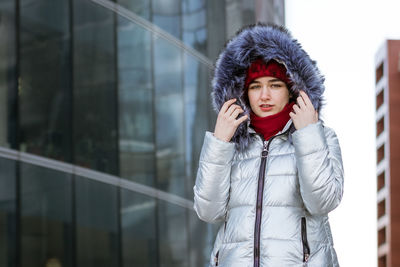 Woman in a warm jacket on the street near the building