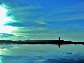 Swan swimming in lake against blue sky