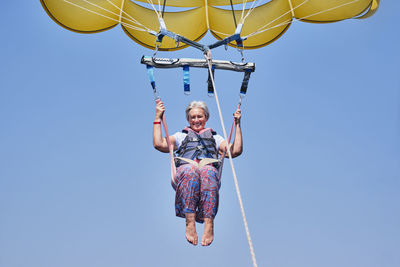 Low angle view of woman standing against sky