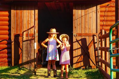 Portrait of girls standing against built structure