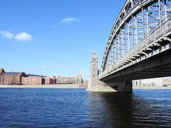 Arch bridge over river against sky in city