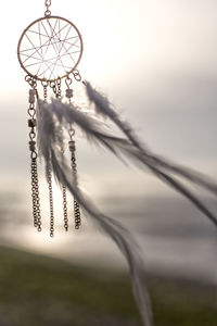 Close-up of hanging light against sky