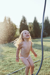 Cheerful shirtless girl enjoying at yard