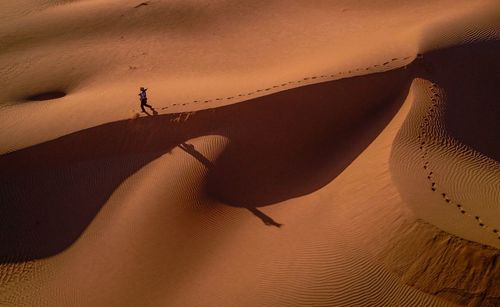 High angle view of man walking on sand dune