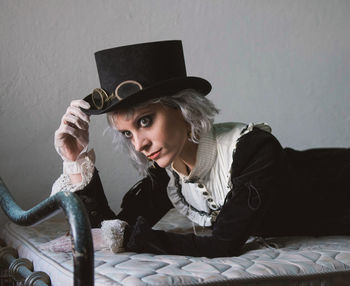 Woman wearing costume while lying on bed at home