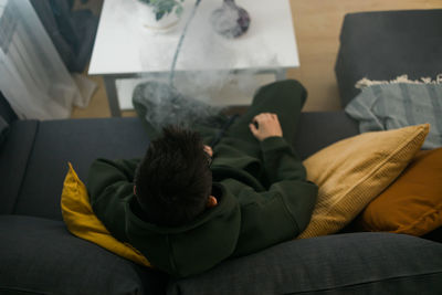 High angle view of woman sitting on bed at home