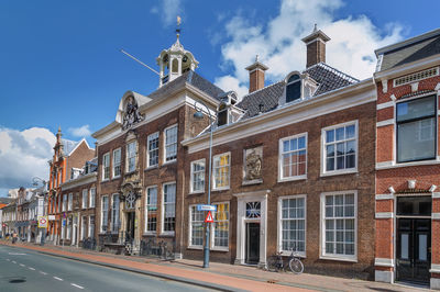 Buildings by street against sky