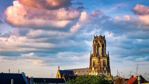 Low angle view of buildings against cloudy sky