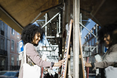 Happy young woman shopping outside store