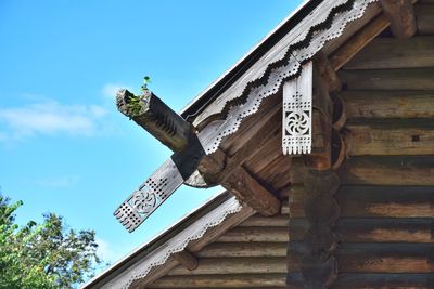 Low angle view of cross on roof against sky