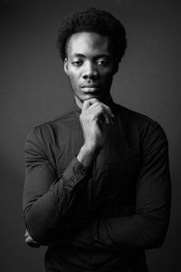 Portrait of young man against gray background