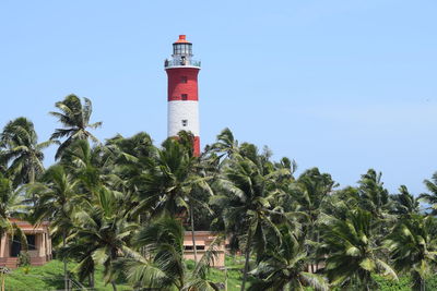 Lighthouse amidst trees and plants against sky