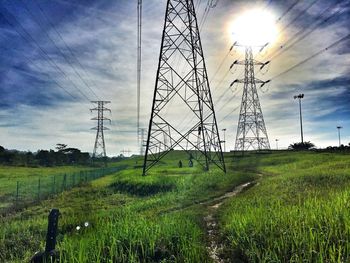 Electricity pylon on grassy field