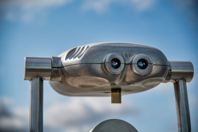 Close-up of coin-operated binoculars against sky