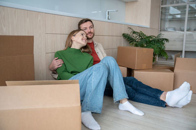 Family couple relaxed man woman dreaming about life in new apartment sitting on floor