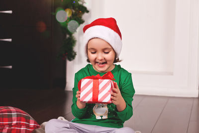 Portrait of cute girl wearing santa hat at home