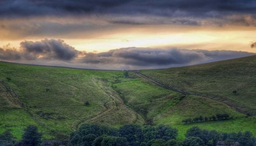 Scenic view of grassy field against cloudy sky