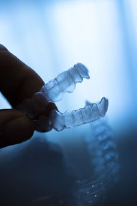 Cropped hand of woman holding dental aligner