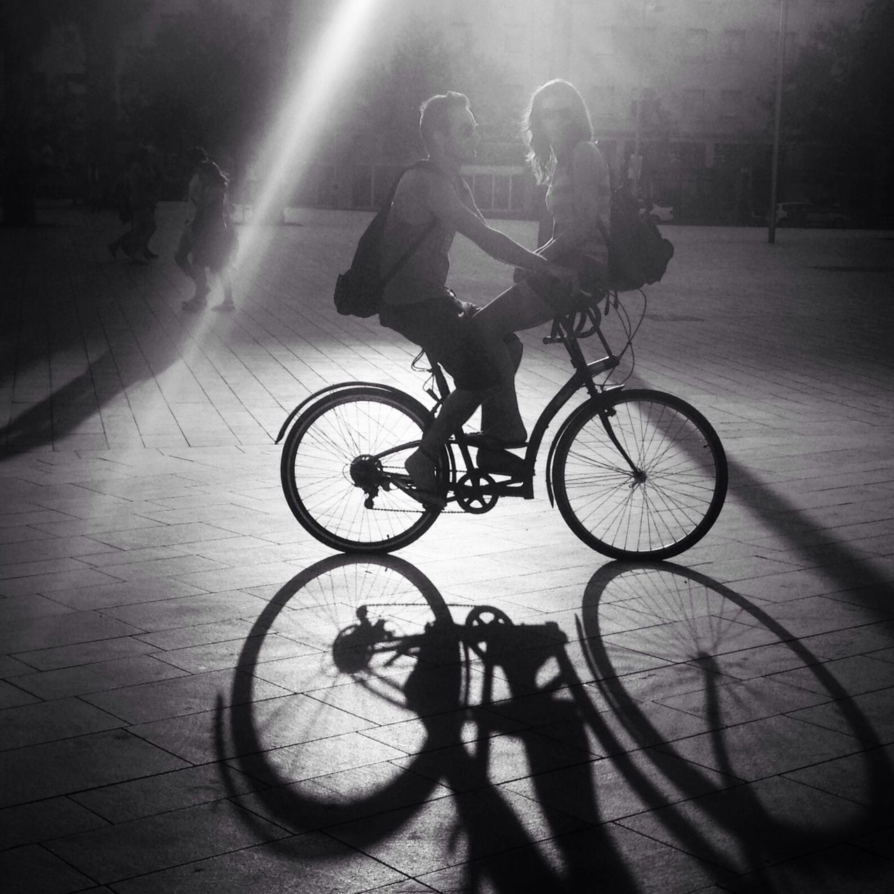 bicycle, transportation, land vehicle, mode of transport, parking, stationary, street, shadow, riding, cycling, parked, sunlight, road, silhouette, travel, outdoors, built structure, night