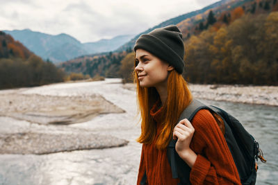 Young woman looking away while standing on mountain