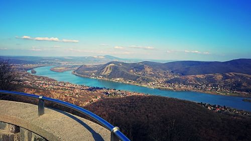 Aerial view of bridge over bay against blue sky