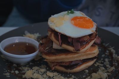 Close-up of fried egg with pancakes and meat in plate