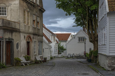 Empty road amidst old buildings against sky