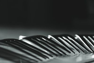 Close-up of forks on table against black background