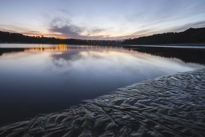 Scenic view of lake against sky at sunset