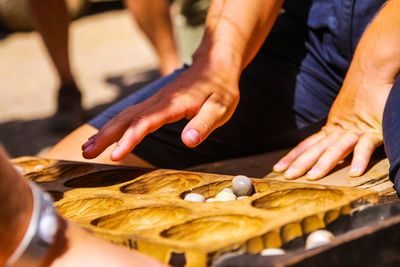 Midsection of people playing game on street in city