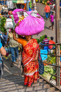 Rear view of people walking on street in rain