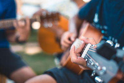 Midsection of man playing guitar
