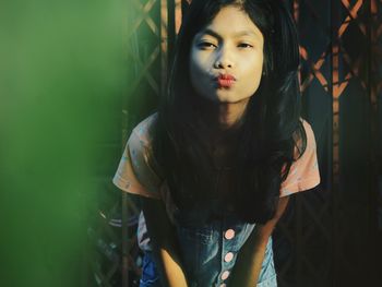 Portrait of girl puckering lips while standing outdoors