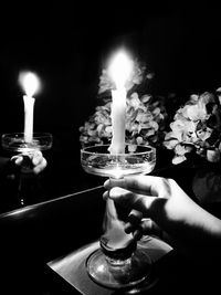 Close-up of hand holding lit candles