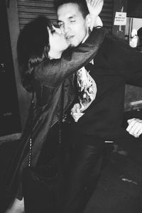 Young couple standing against wall