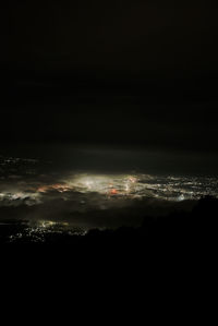 Aerial view of illuminated landscape against sky at night