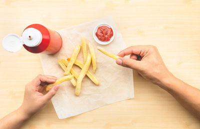 High angle view of hand holding food on table