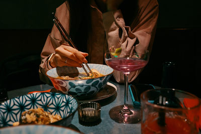 Midsection of woman having food on table