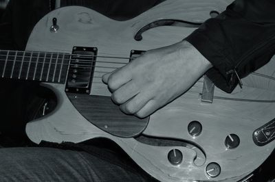 Midsection of man playing guitar