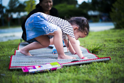 Side view of girl playing with ball on field